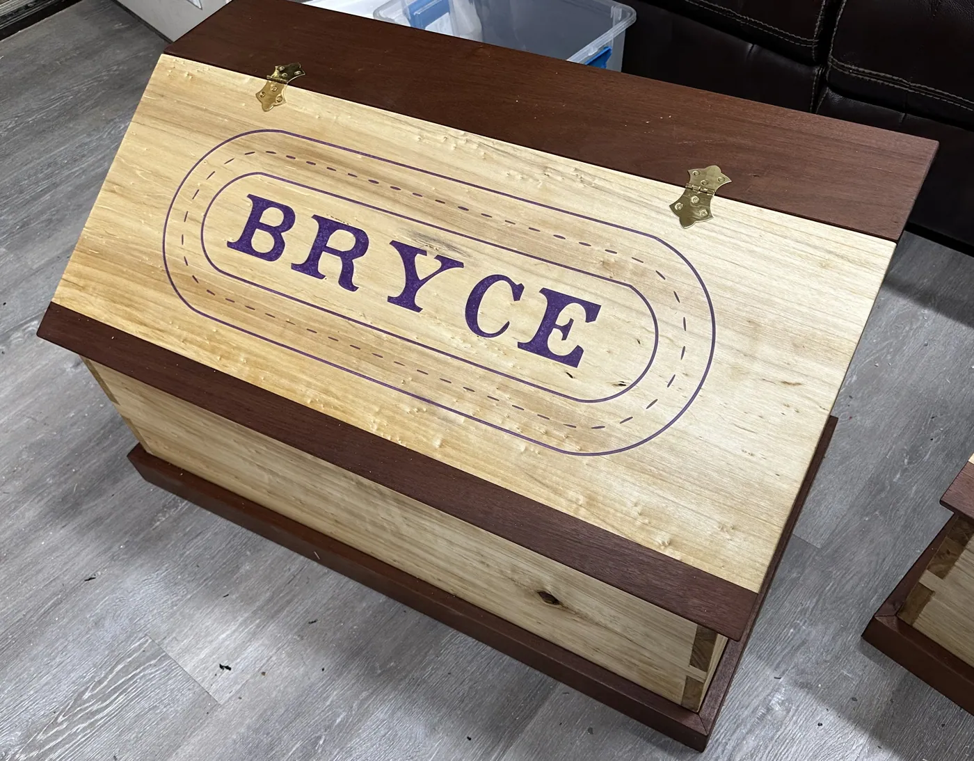 Children's keepsake chest with a birdseye maple lid engraved with the name, trimmed in mahogany.