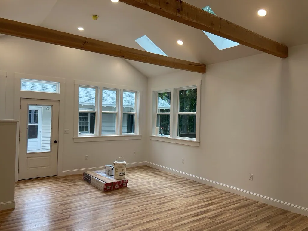 An accessory dwelling unit finished with a vaulted ceiling, exposed beam, and skylights.