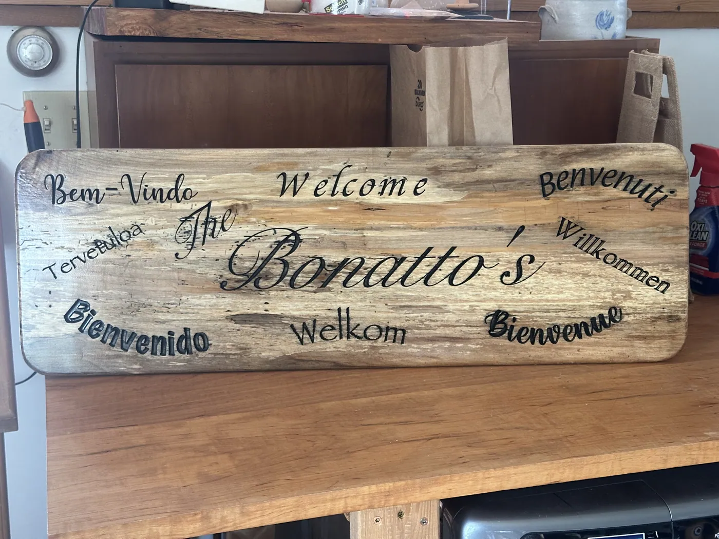 Spalted maple welcome sign greeting guests with welcome in several languages.