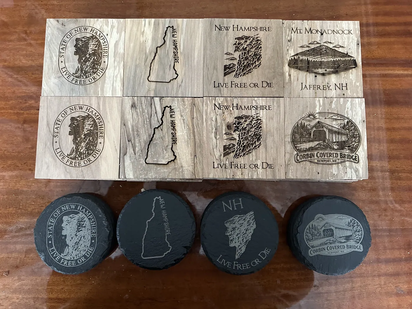 New Hampshire designs engraved on spalted wood and round slate coasters.