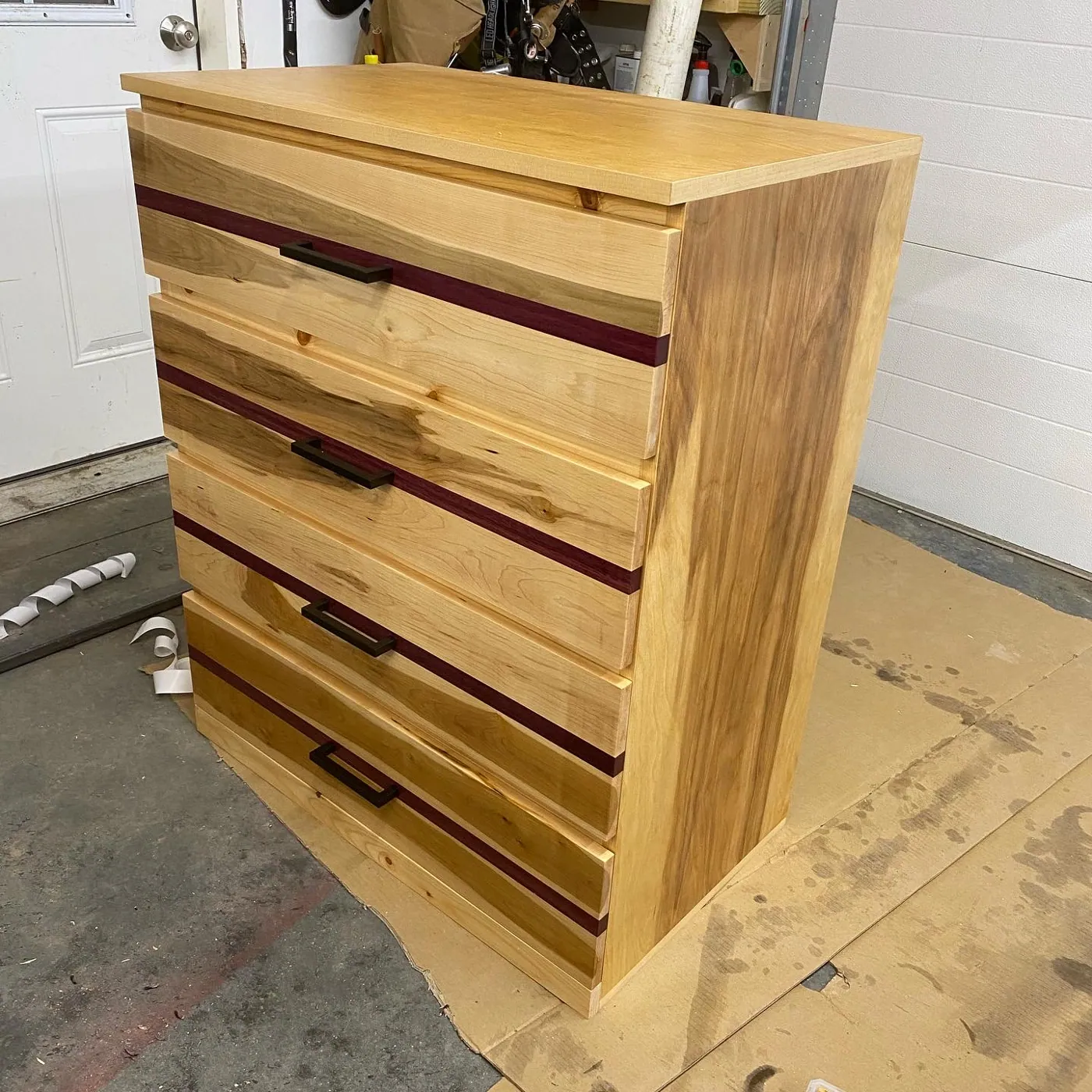 Four-drawer bureau in hickory and maple, accented with inset purpleheart stripes.