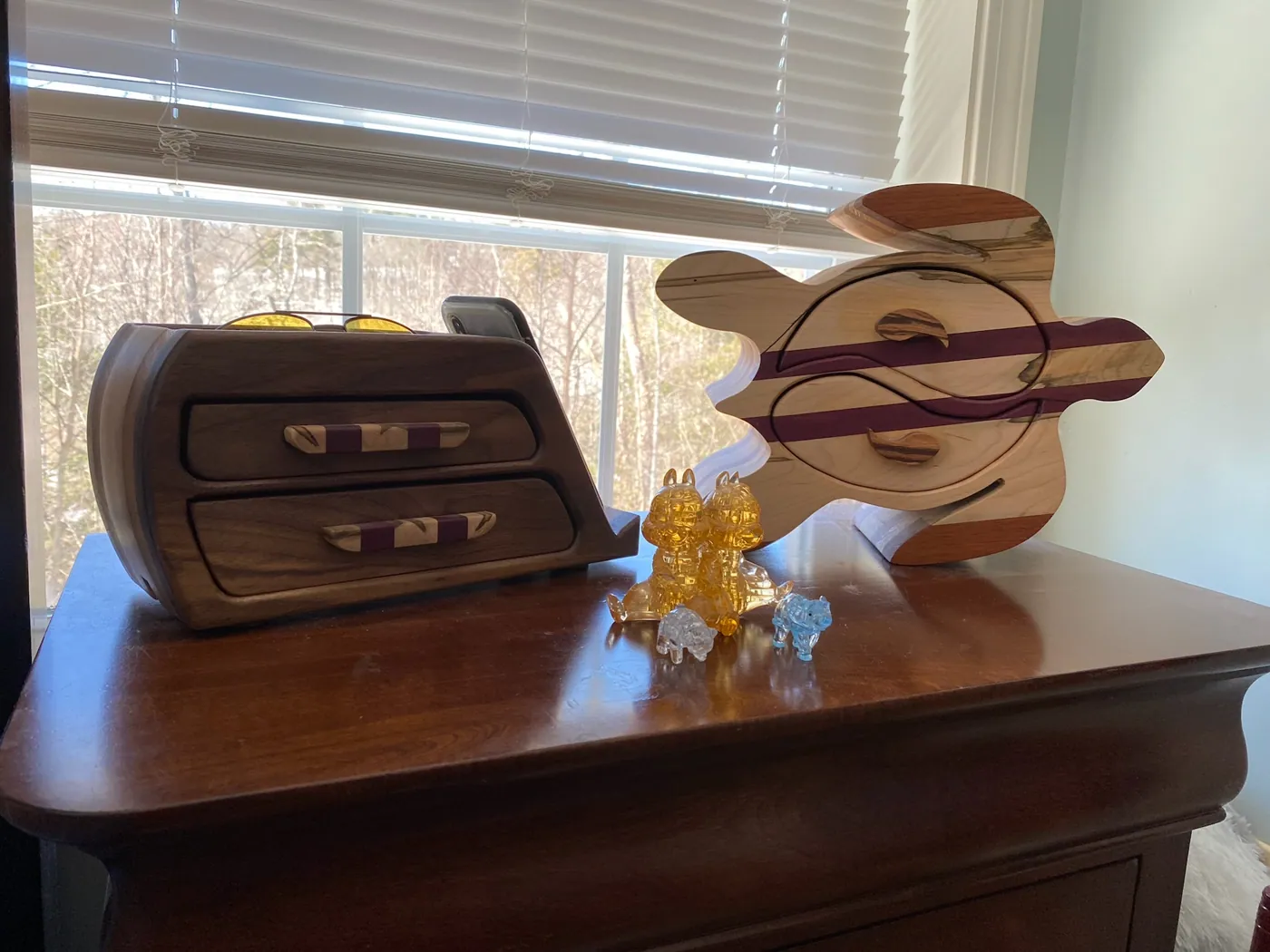 Curved walnut valet box with felt-lined compartments and an integrated phone stand.