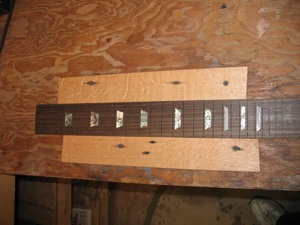 Rosewood fretboard with abalone trapezoid inlays set in