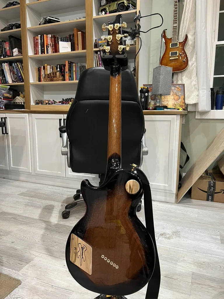 Finished custom maple Les Paul style guitar with a black walnut top and gold hardware