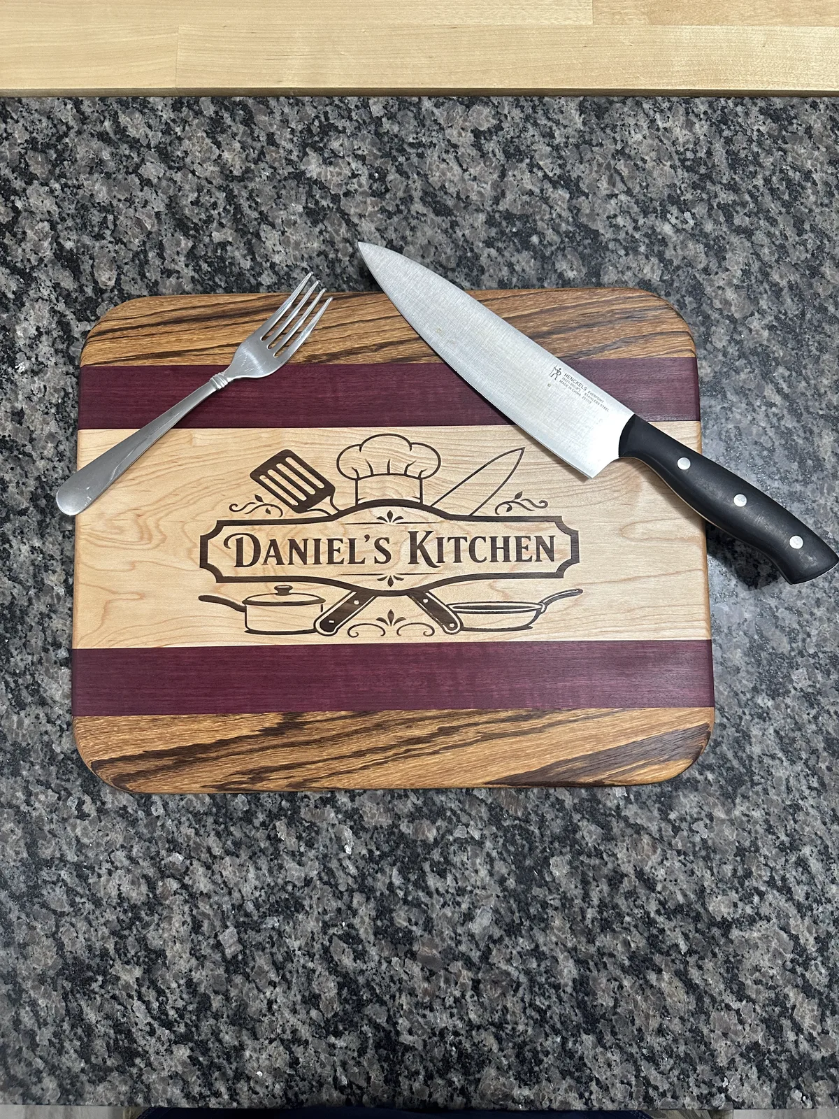 Purpleheart, maple, and zebrawood cutting board with a walnut inlay