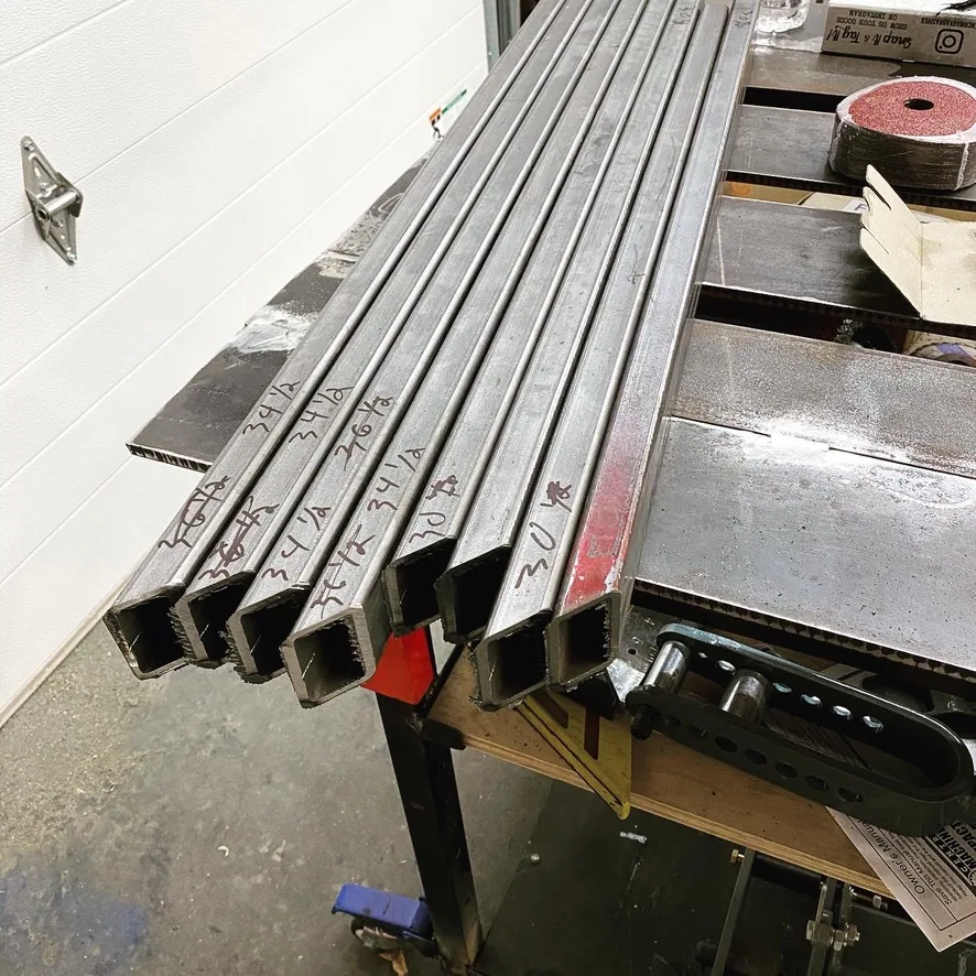Welded steel square-tube legs with a hammered wrought-iron finish